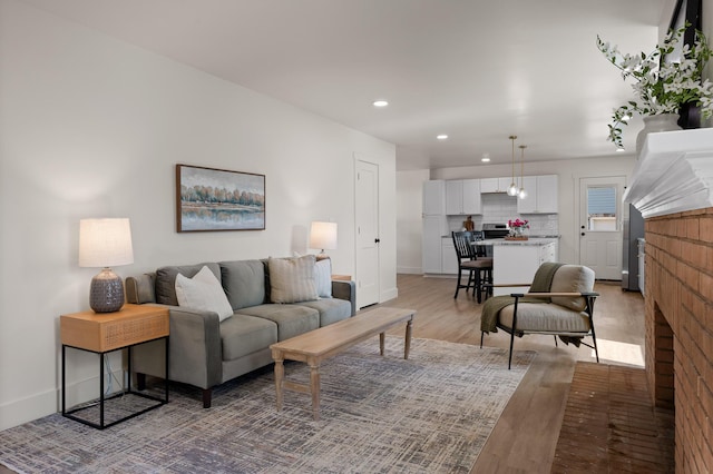 living room featuring recessed lighting, light wood-style flooring, and baseboards