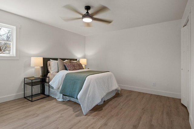 bedroom with baseboards, light wood-style flooring, and a ceiling fan