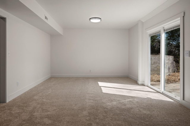 carpeted empty room with visible vents and baseboards