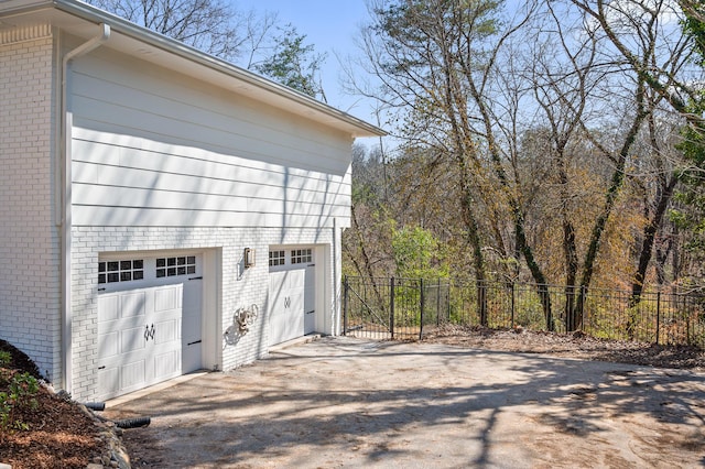 garage featuring fence and driveway