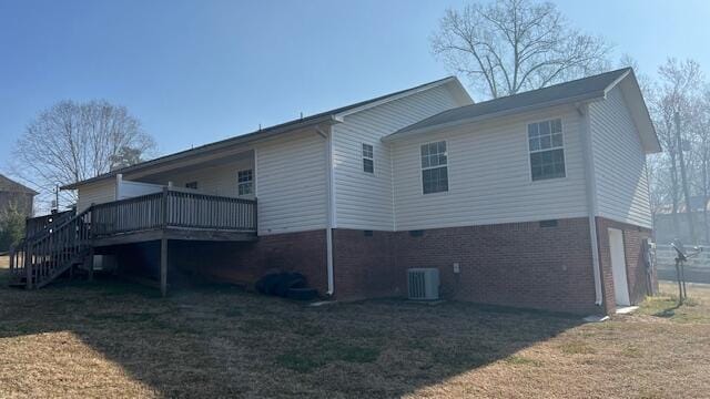 rear view of house with a deck, a yard, stairway, brick siding, and central AC unit