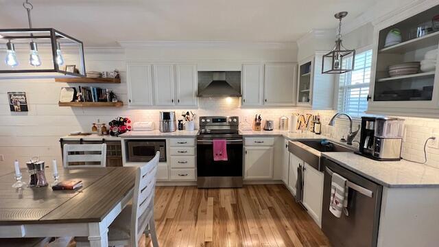 kitchen featuring open shelves, appliances with stainless steel finishes, exhaust hood, white cabinetry, and a sink