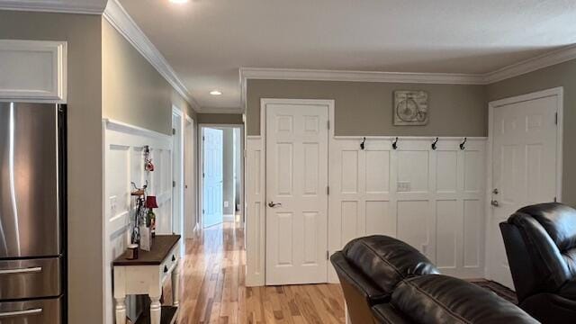 interior space with light wood-style flooring and ornamental molding