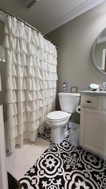 bathroom featuring vanity, toilet, visible vents, and ornamental molding