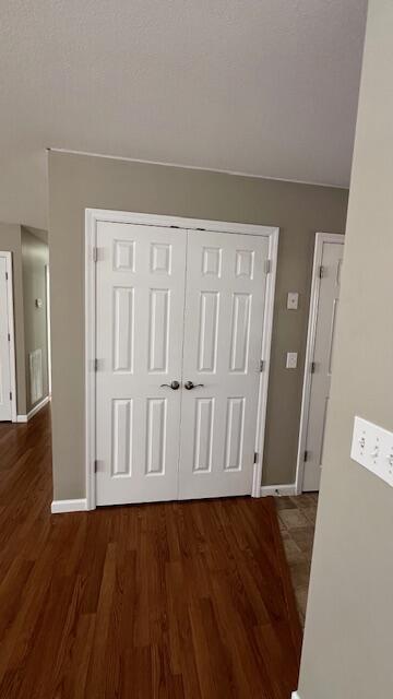 hall with baseboards and wood finished floors