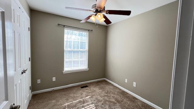 unfurnished room featuring visible vents, ceiling fan, baseboards, and carpet