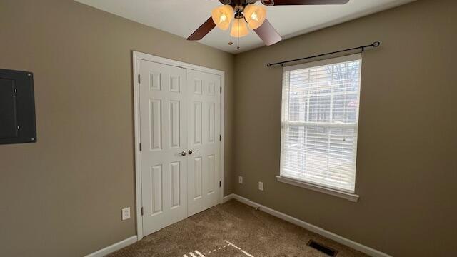 unfurnished bedroom with electric panel, visible vents, multiple windows, and a closet