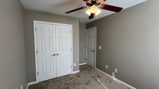 unfurnished bedroom featuring a closet, baseboards, a ceiling fan, and carpet flooring