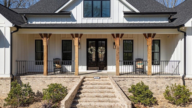 view of exterior entry with covered porch, board and batten siding, and a shingled roof