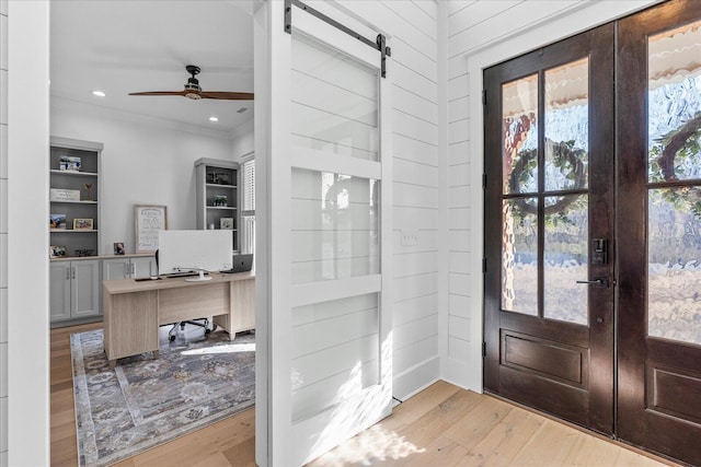 doorway to outside with a barn door, recessed lighting, light wood-style flooring, french doors, and a ceiling fan