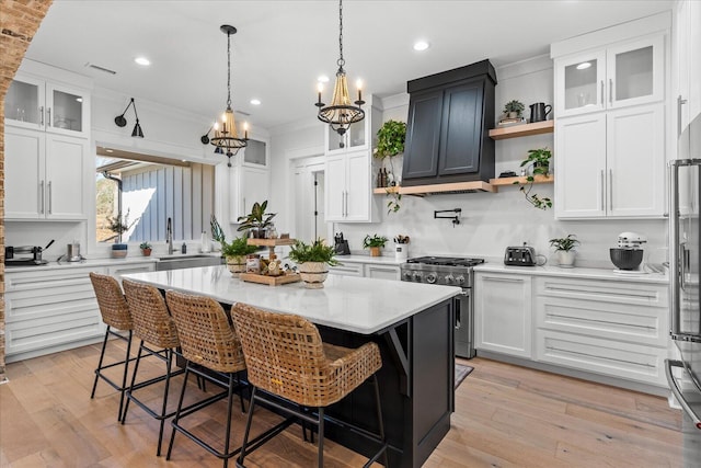 kitchen with visible vents, white cabinetry, and high end stainless steel range