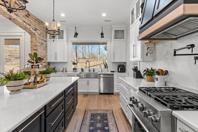 kitchen with a healthy amount of sunlight, appliances with stainless steel finishes, white cabinetry, and a sink