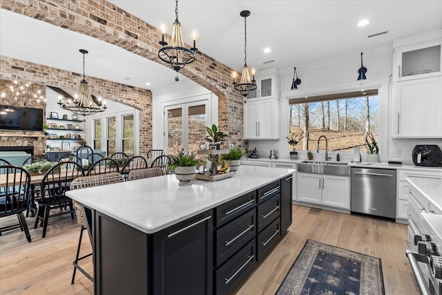 kitchen with white cabinets, dishwasher, brick wall, and dark cabinets