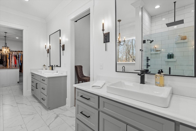 full bathroom featuring a tile shower, marble finish floor, crown molding, and a sink