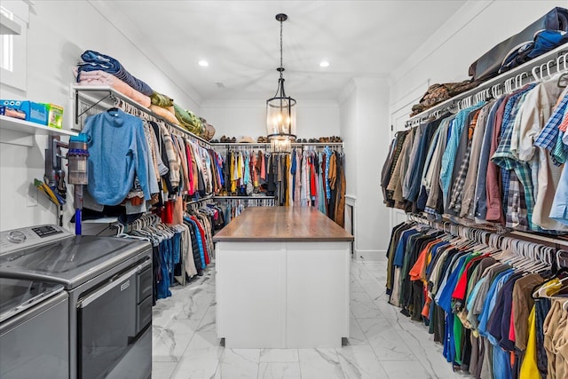 walk in closet with an inviting chandelier, marble finish floor, and washing machine and clothes dryer