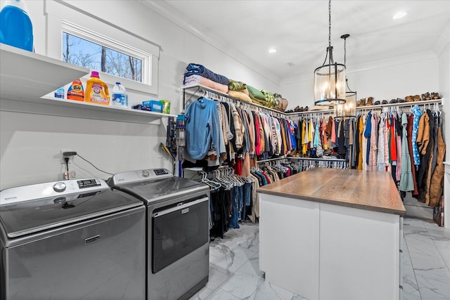 interior space with crown molding, washing machine and dryer, recessed lighting, cabinet space, and marble finish floor