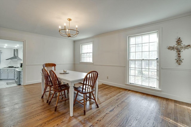 dining area featuring baseboards, an inviting chandelier, light wood-style flooring, and ornamental molding