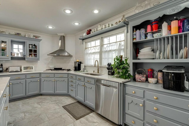 kitchen with gray cabinets, dishwasher, wall chimney exhaust hood, and a sink