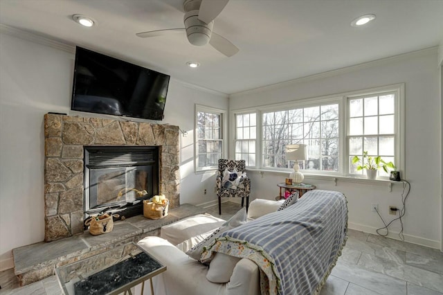 living room featuring crown molding, baseboards, ceiling fan, recessed lighting, and a fireplace