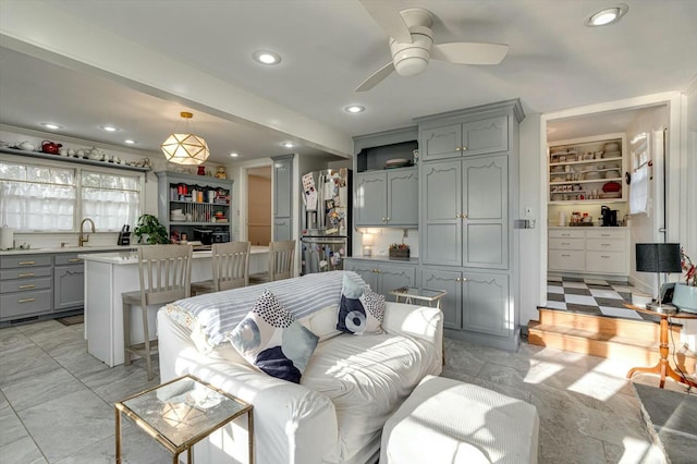 living room with a ceiling fan, built in features, recessed lighting, and marble finish floor