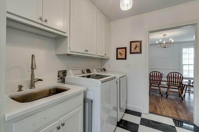 clothes washing area featuring tile patterned floors, a sink, cabinet space, crown molding, and washing machine and clothes dryer