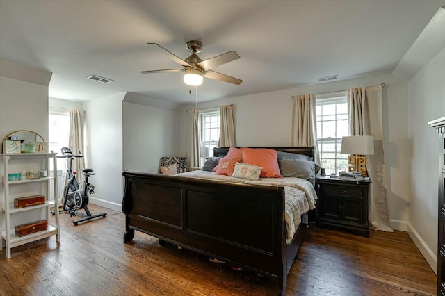 bedroom featuring dark wood finished floors, visible vents, and multiple windows