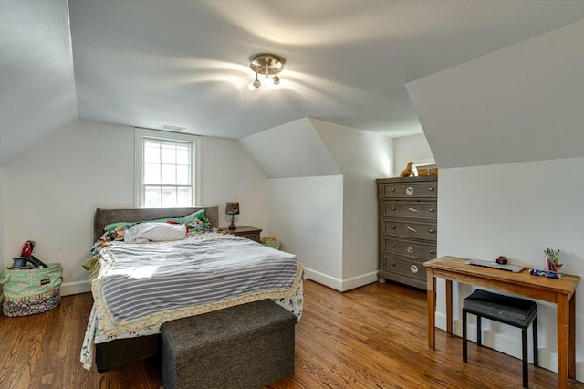 bedroom with visible vents, baseboards, lofted ceiling, and wood finished floors