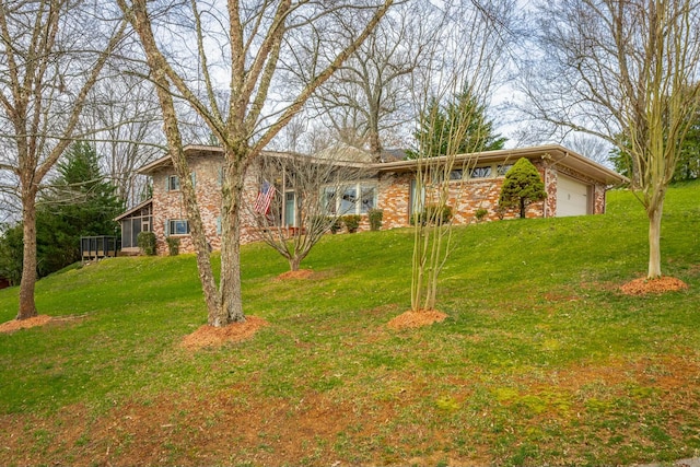 view of front of property featuring a garage, brick siding, and a front yard