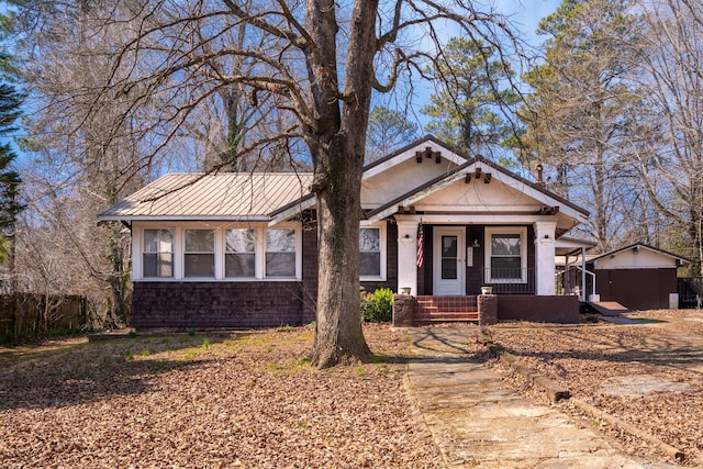 view of front of home featuring covered porch, metal roof, a standing seam roof, and fence