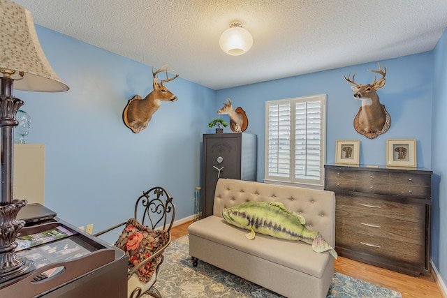 home office featuring baseboards, a textured ceiling, and wood finished floors