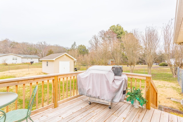 wooden deck with an outdoor structure, a storage unit, a lawn, and grilling area