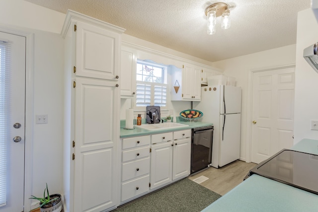 kitchen with a sink, black appliances, and white cabinetry