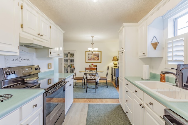 kitchen with a sink, light countertops, under cabinet range hood, range with electric stovetop, and white cabinetry