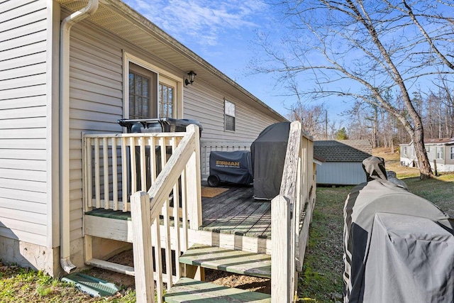 wooden deck featuring an outbuilding and a shed