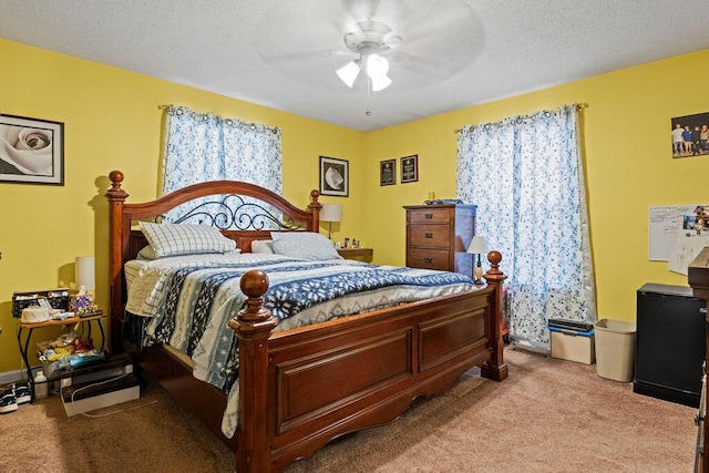 bedroom with light colored carpet, a textured ceiling, and ceiling fan