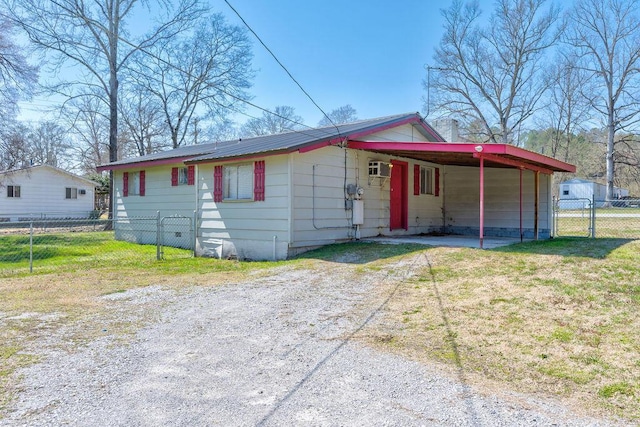 view of front of house featuring a gate, fence, driveway, a carport, and a front lawn