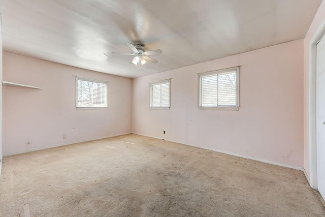 carpeted spare room with a ceiling fan