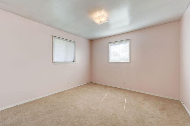 empty room with light colored carpet and baseboards