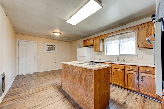 kitchen with a wall mounted air conditioner, brown cabinets, a sink, a center island, and white appliances