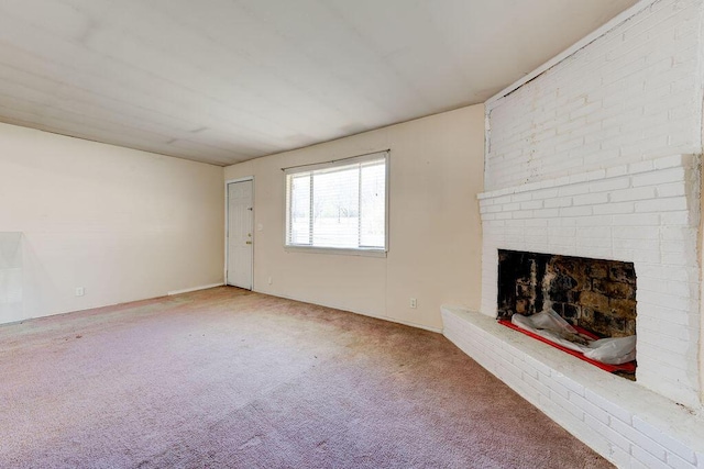 unfurnished living room with a brick fireplace and carpet