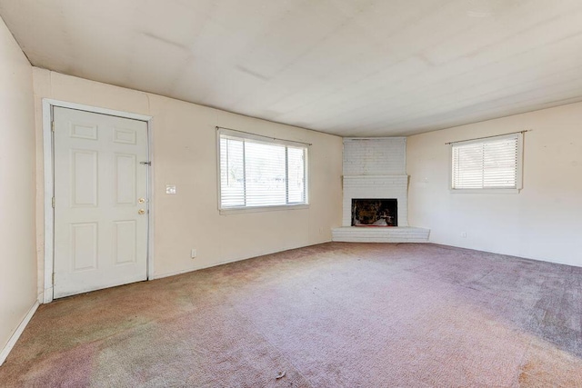 unfurnished living room with a brick fireplace and carpet flooring