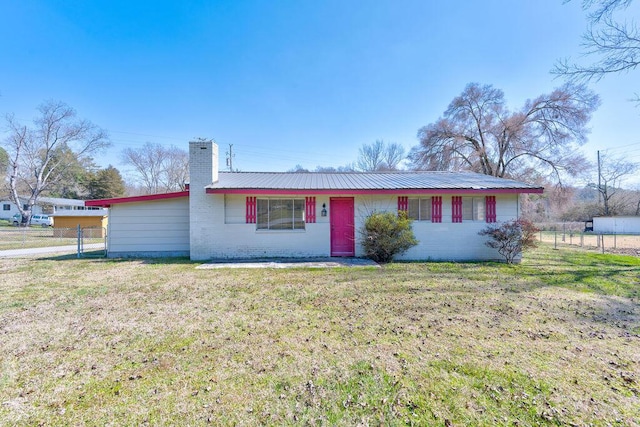 ranch-style house featuring a front lawn, fence, metal roof, brick siding, and a chimney