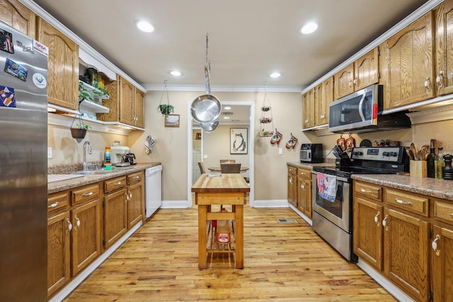 kitchen featuring baseboards, recessed lighting, brown cabinets, light wood-style floors, and stainless steel appliances