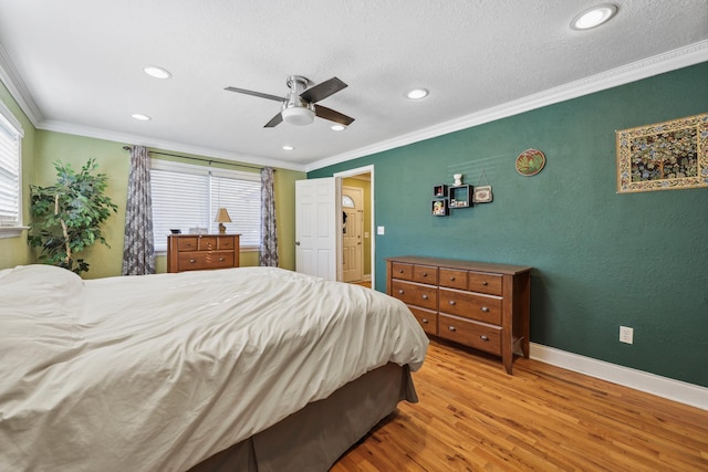 bedroom with ornamental molding, a ceiling fan, a textured ceiling, wood finished floors, and baseboards