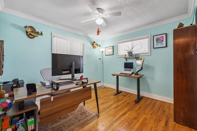 office space with light wood-type flooring, baseboards, a textured ceiling, and ornamental molding