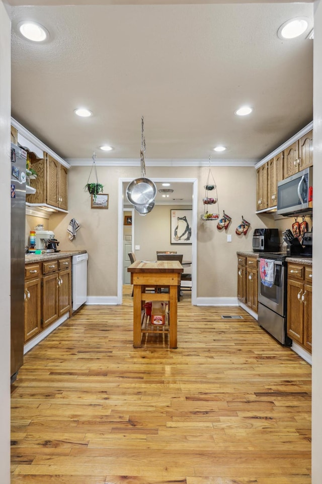 kitchen with crown molding, light wood-type flooring, brown cabinets, and stainless steel appliances