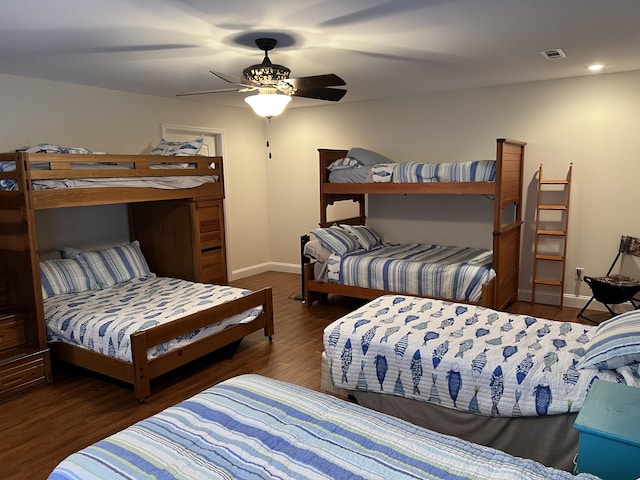 bedroom featuring visible vents, baseboards, wood finished floors, and a ceiling fan