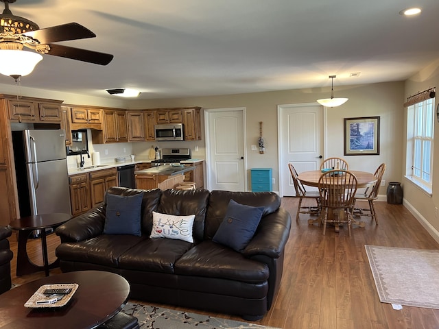 living room with dark wood finished floors, ceiling fan, and baseboards