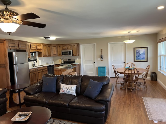 living area featuring ceiling fan, baseboards, and dark wood-style floors