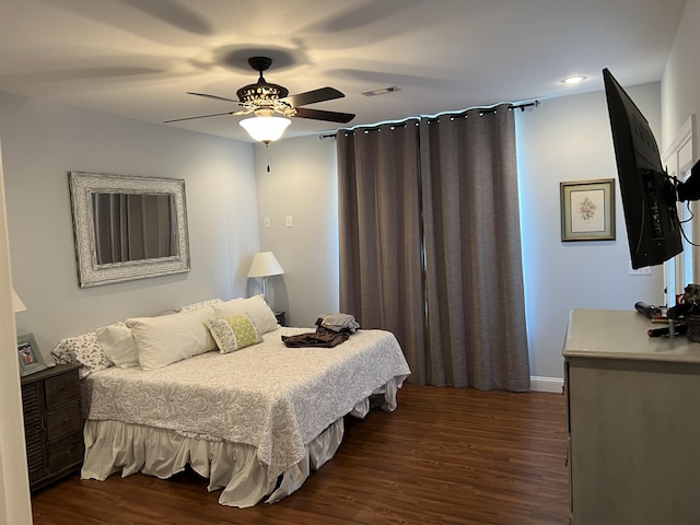 bedroom featuring a ceiling fan, visible vents, and dark wood-style flooring